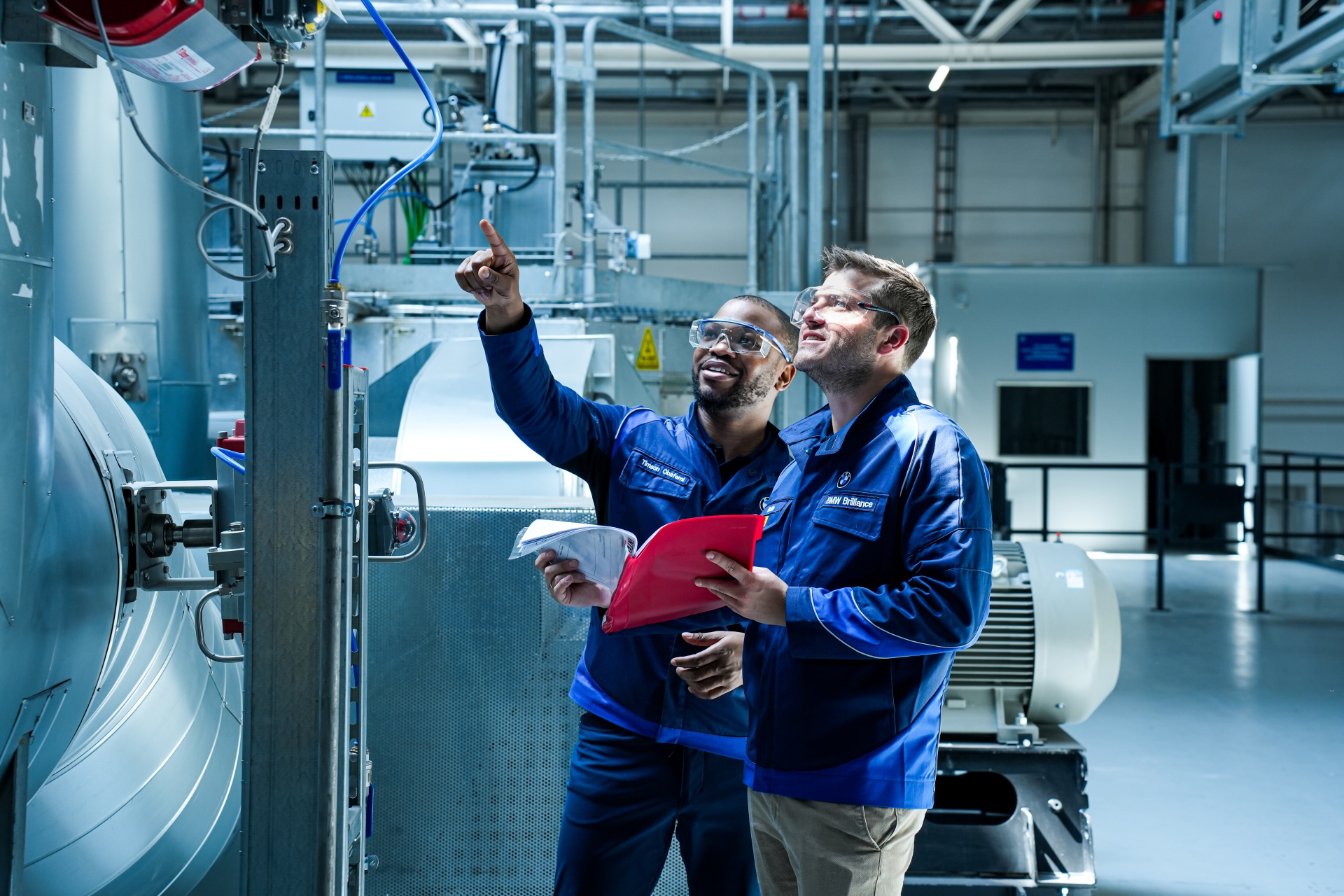 Dos ingenieros analizando maquinaria en planta de BMW Group.