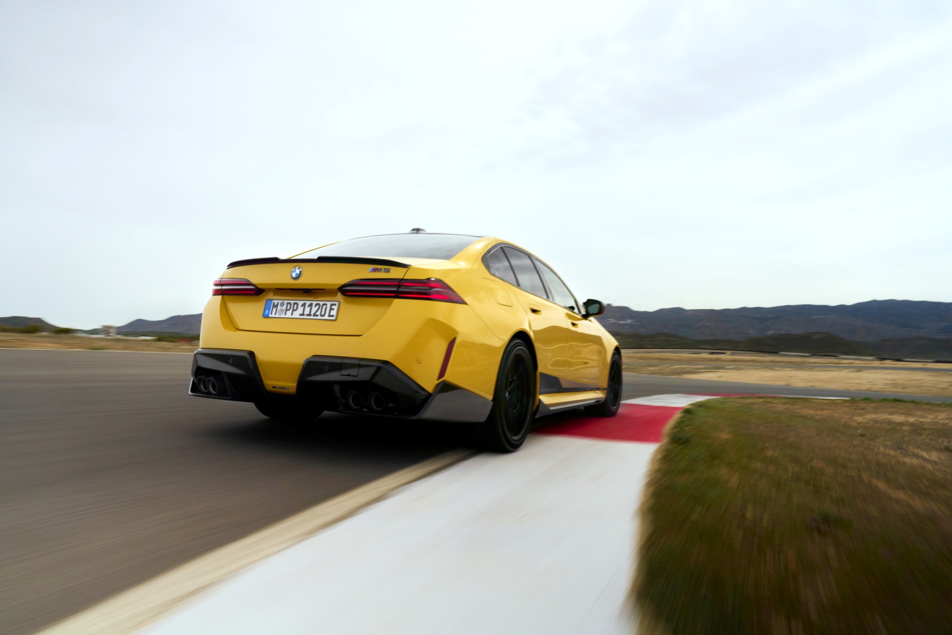 BMW M5 en pista, mostrando su dinámica trasera y línea lateral deportiva.