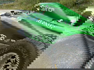 Vista lateral Caterham CT05 mostrando aerodinámica y neumáticos