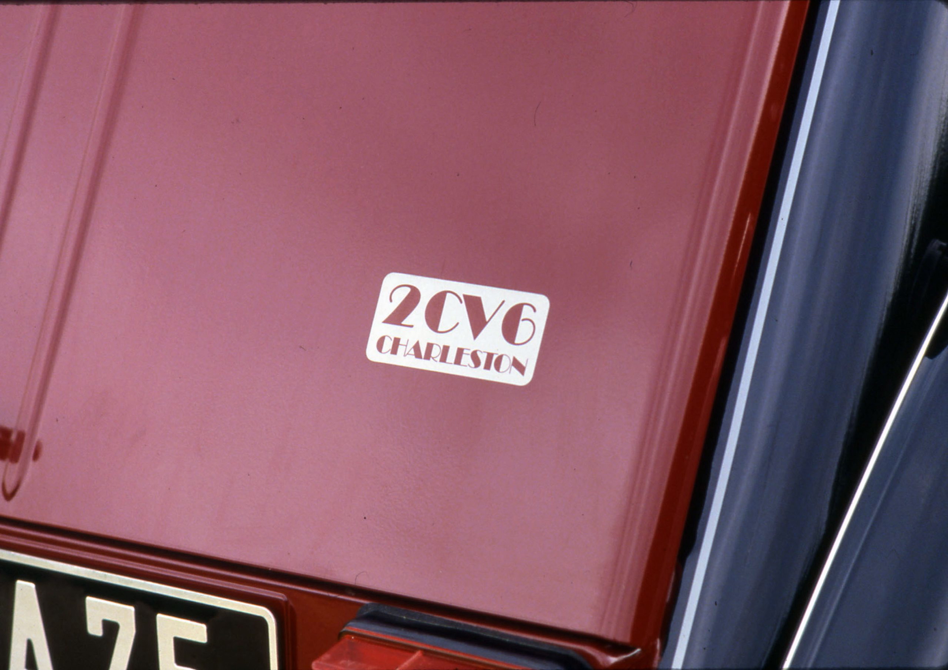 Detalle emblemático del Citroën 2CV Charleston en acabado burdeos y negro.