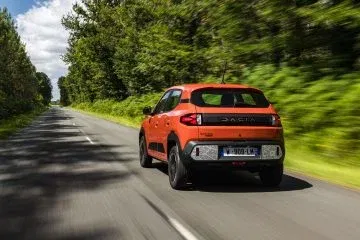 El Dacia Spring 2024 circula por una carretera rodeada de naturaleza. El Dacia Spring 2024 circula por una carretera rodeada de naturaleza.