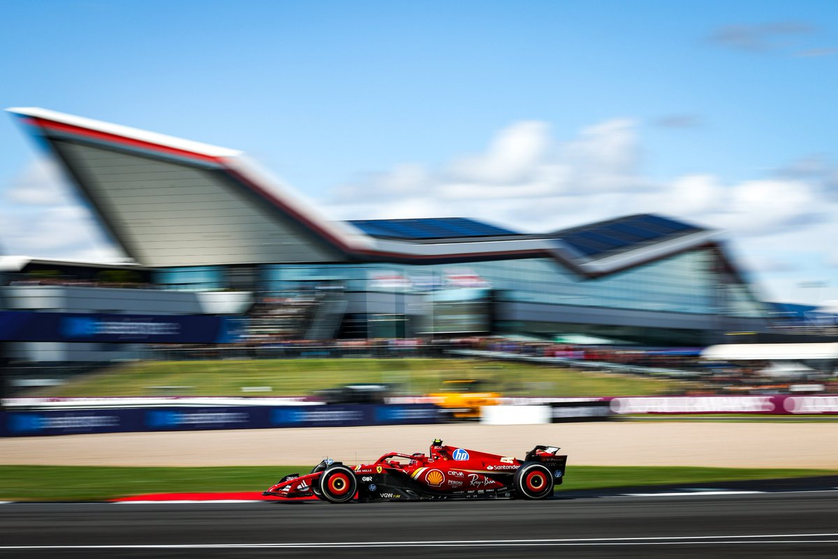 Un F1 de Ferrari negociando una curva en Silverstone bajo cielo azul
