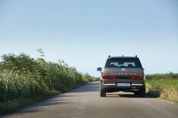Vista dinámica del Hyundai Santa Fe 2024 en carretera, destacando su diseño trasero y lateral.