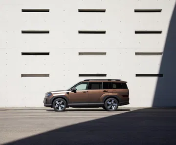 La imagen muestra el Hyundai Santa Fe 2024 en una perspectiva lateral, destacando su línea dinámica.