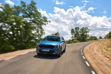 SUV Kia Sorento 2024 rodando con soltura, muestra su diseño frontal y lateral.