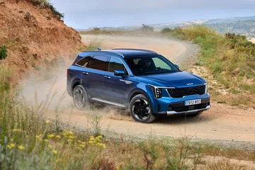 El Kia Sorento 2024 posa en terreno abrupto, mostrando su perfil robusto y líneas modernas.