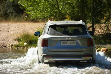Vista de Kia Sorento 2024 superando obstáculo acuático, destacando su capacidad todoterreno.