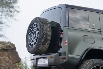 Imponente toma del Land Rover Defender superando obstáculos off-road.