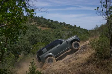 Land Rover Defender superando terreno accidentado con destreza.