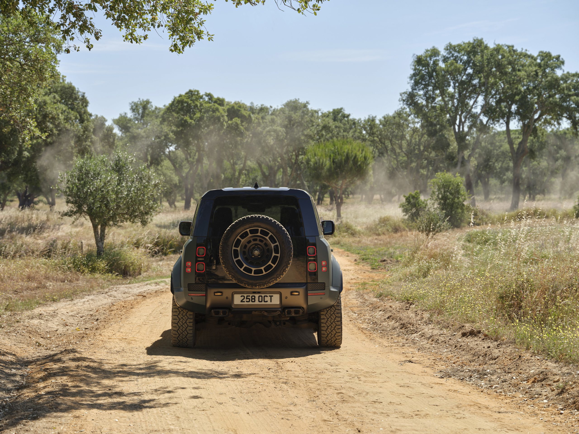 Vista trasera del Land Rover Defender en acción off-road, mostrando su robustez y capacidades todoterreno.
