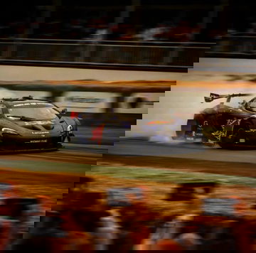 Mclaren P1 GTR derrapando en pista, espectáculo de fuego y velocidad.
