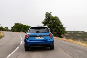 Vista trasera del Mini Cooper S en acción, destacando su diseño deportivo y compacto.