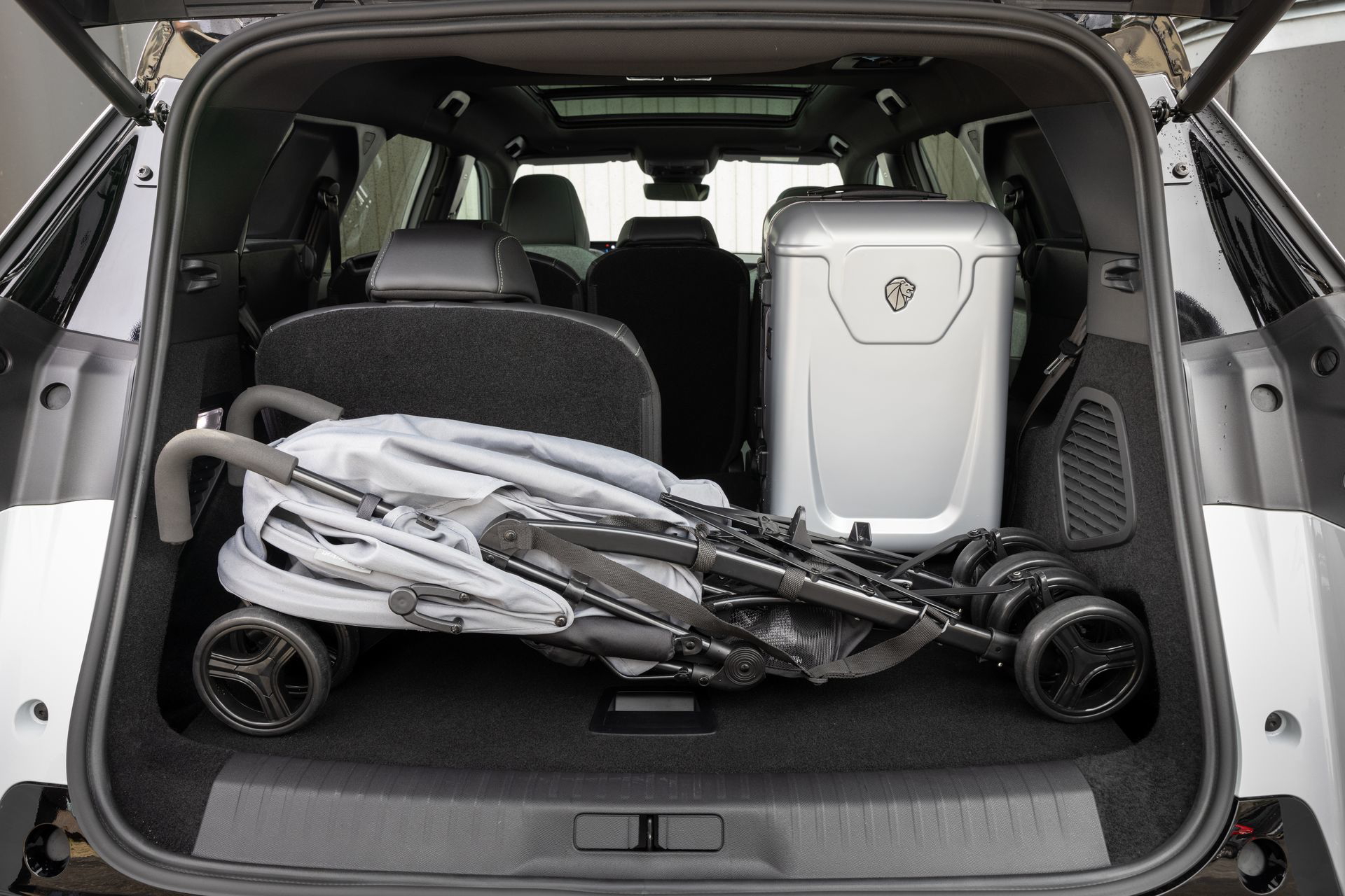 Vista del espacioso maletero del Peugeot 5008 con silla de bebé, destacando su capacidad.