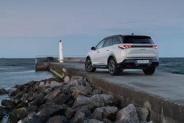 Vista dinámica del Peugeot 5008 2025 sobre un muelle, destacando su diseño robusto y elegante.