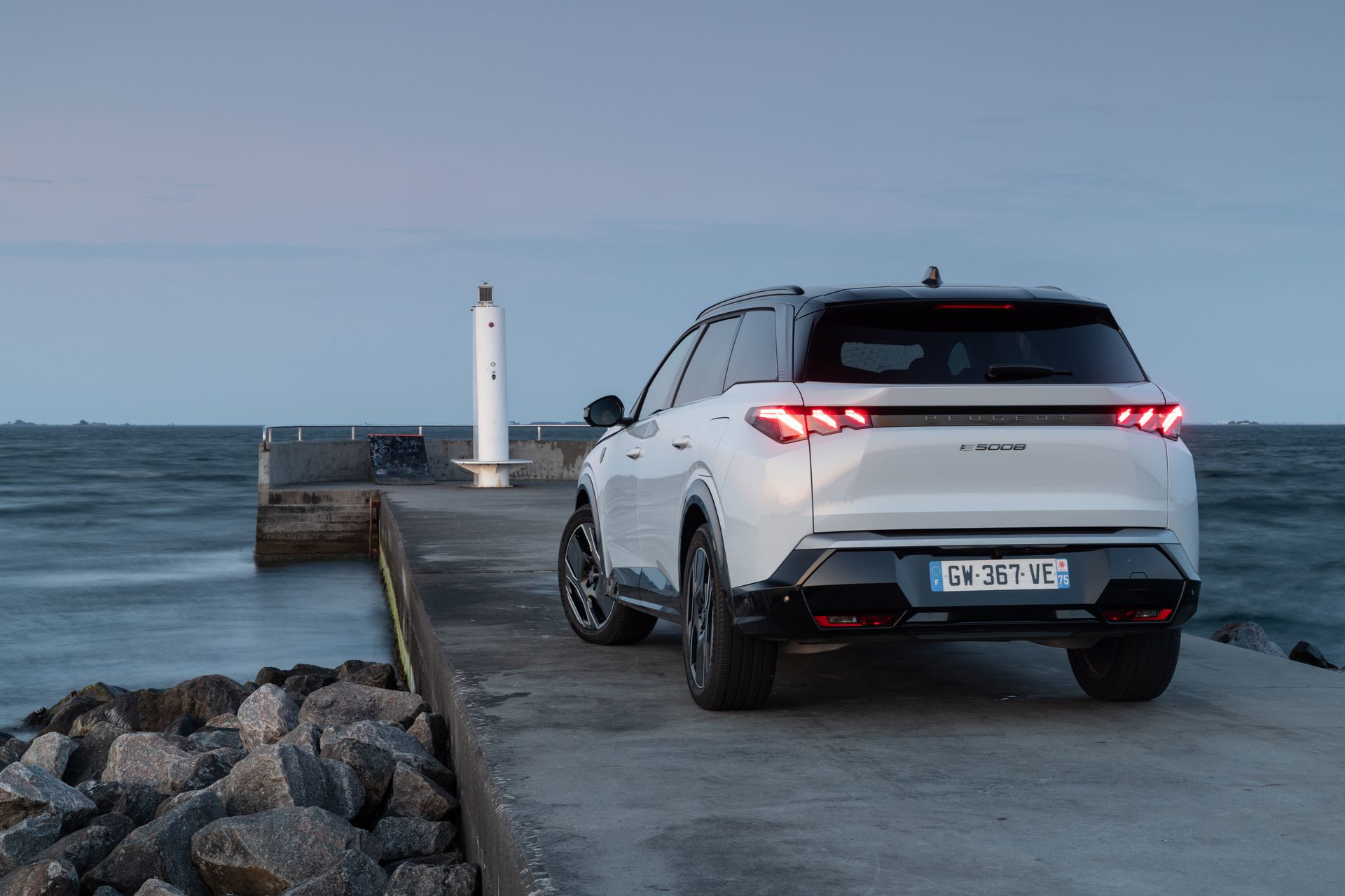 Vista trasera y lateral del Peugeot 5008 2024 aparcado en un dique