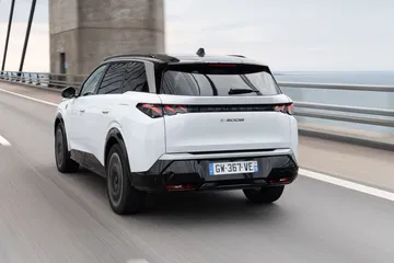 Vista dinámica del Peugeot 5008 2024 en carretera, destacando su diseño trasero y lateral.