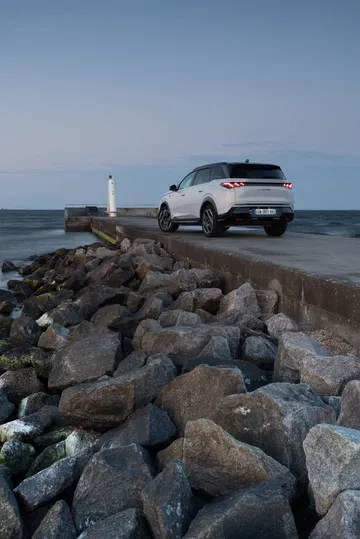 Vista trasera y lateral del Peugeot 5008 2025 en un entorno marítimo