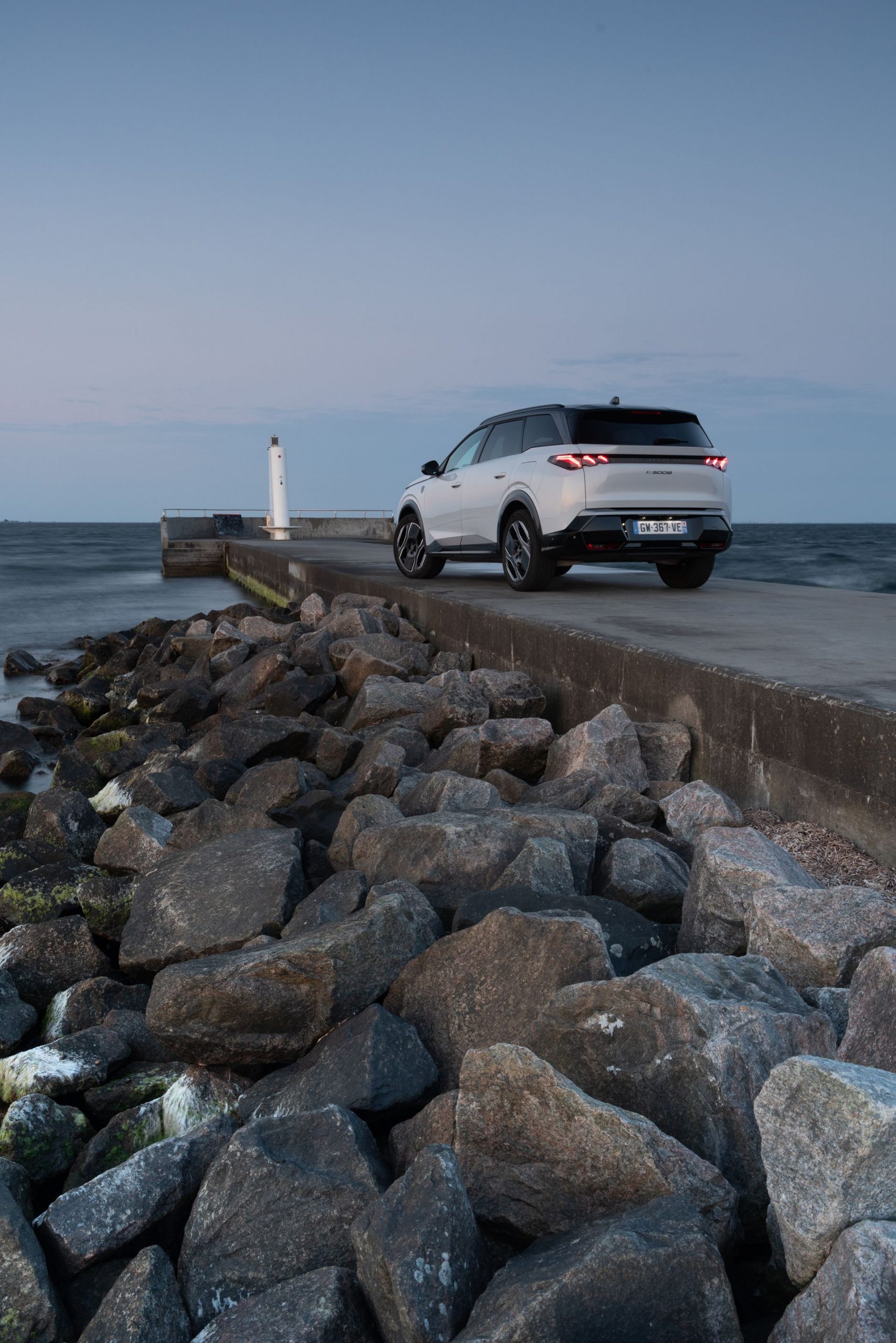 Vista trasera y lateral del Peugeot 5008 2025 en un entorno marítimo