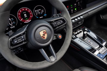 Vista detallada del volante y consola central del Porsche 911 GTS T-Hybrid.