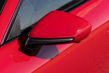 Vista del espejo retrovisor en acabado rojo, un detalle icónico del Porsche 911.