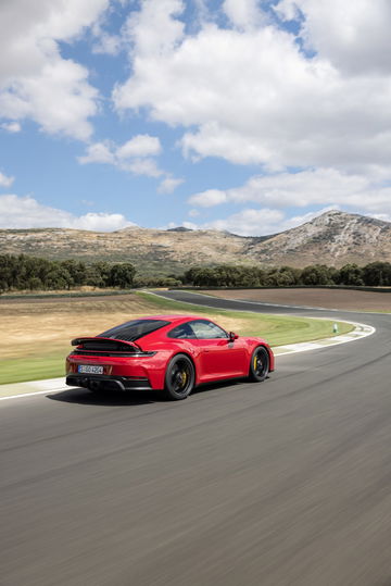 Porsche 911 GTS T-Hybrid mostrando su atlética silueta lateral en movimiento.