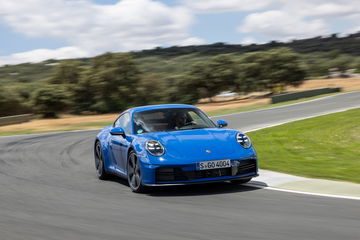 Porsche 911 híbrido azul en pista, perfección en movimiento.
