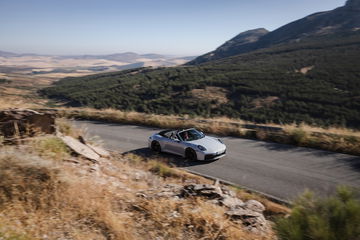 Vista lateral del Porsche 911 GTS T-Hybrid en entorno natural.