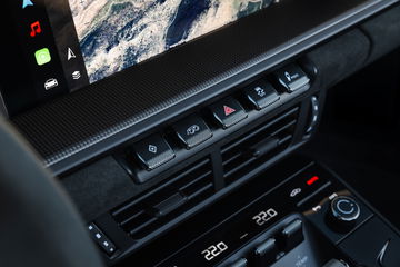 Vista del elegante panel de control y ajustes climáticos del Porsche 911.