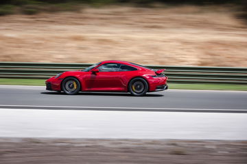 Un Porsche 911 GTS T-Hybrid exhibiendo su aerodinámica en pista.
