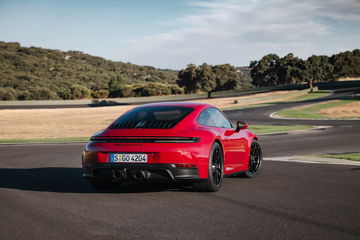 Vista dinámica del Porsche 911 GTS T-Hybrid destacando su silueta y diseño trasero.