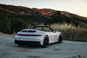 Vista trasera y lateral del Porsche 911 GTS T-Hybrid en ambiente natural.