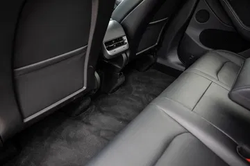 Vista lateral de los asientos traseros del Tesla Model Y con detalle de acabados y ajustes.