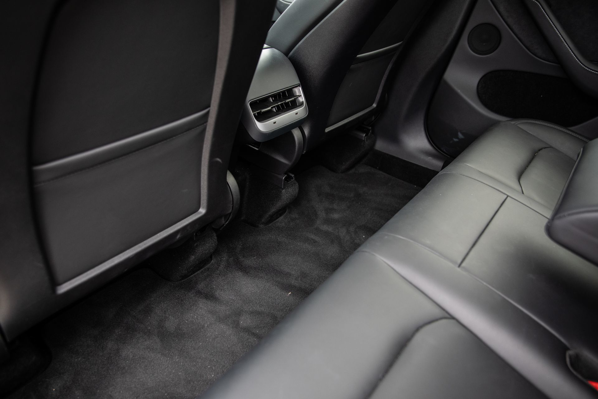 Vista lateral de los asientos traseros del Tesla Model Y con detalle de acabados y ajustes.