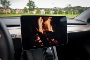 Pantalla central Tesla Model Y mostrando animación de fuego, detalle tecnológico vanguardista.