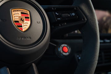 Vista parcial del volante y emblema de Porsche 911 T-Hybrid.