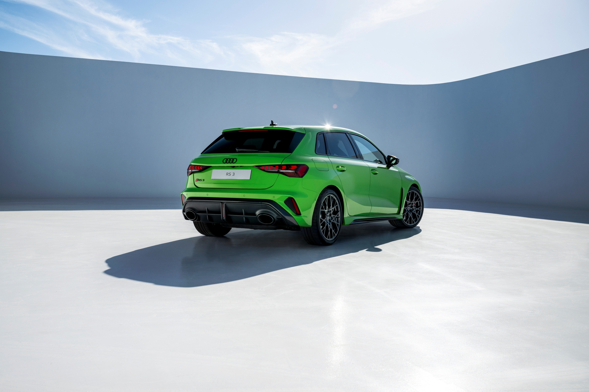 Vista trasera y lateral del Audi RS3 en un tono verde llamativo, reflejando su carácter deportivo.