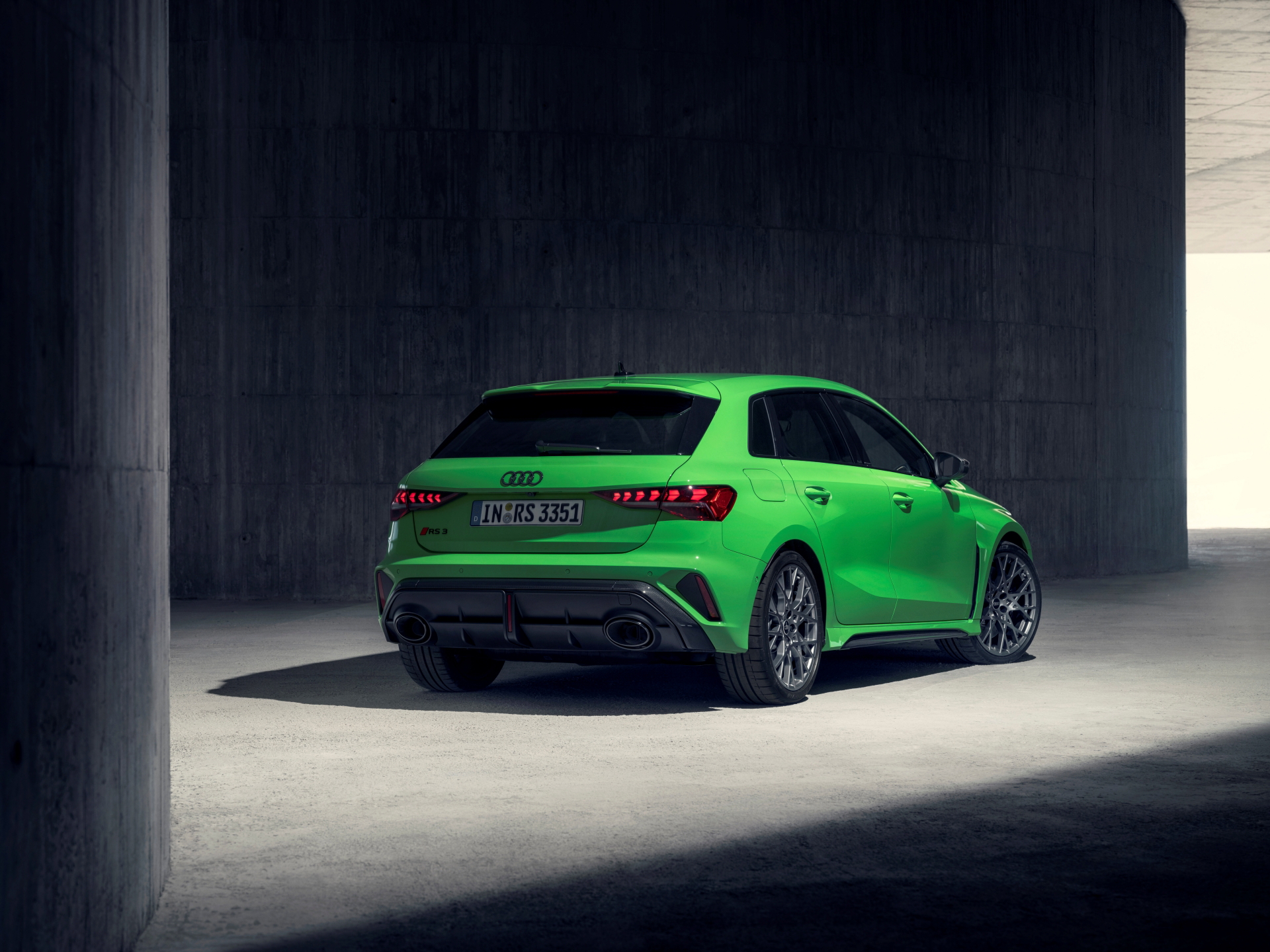 Vista dinámica de la trasera y perfil del Audi RS3, mostrando líneas deportivas.