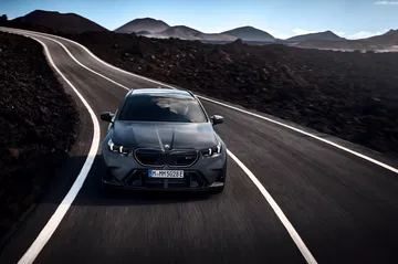 Potente BMW M5 Touring 2025 en carretera serpenteante.