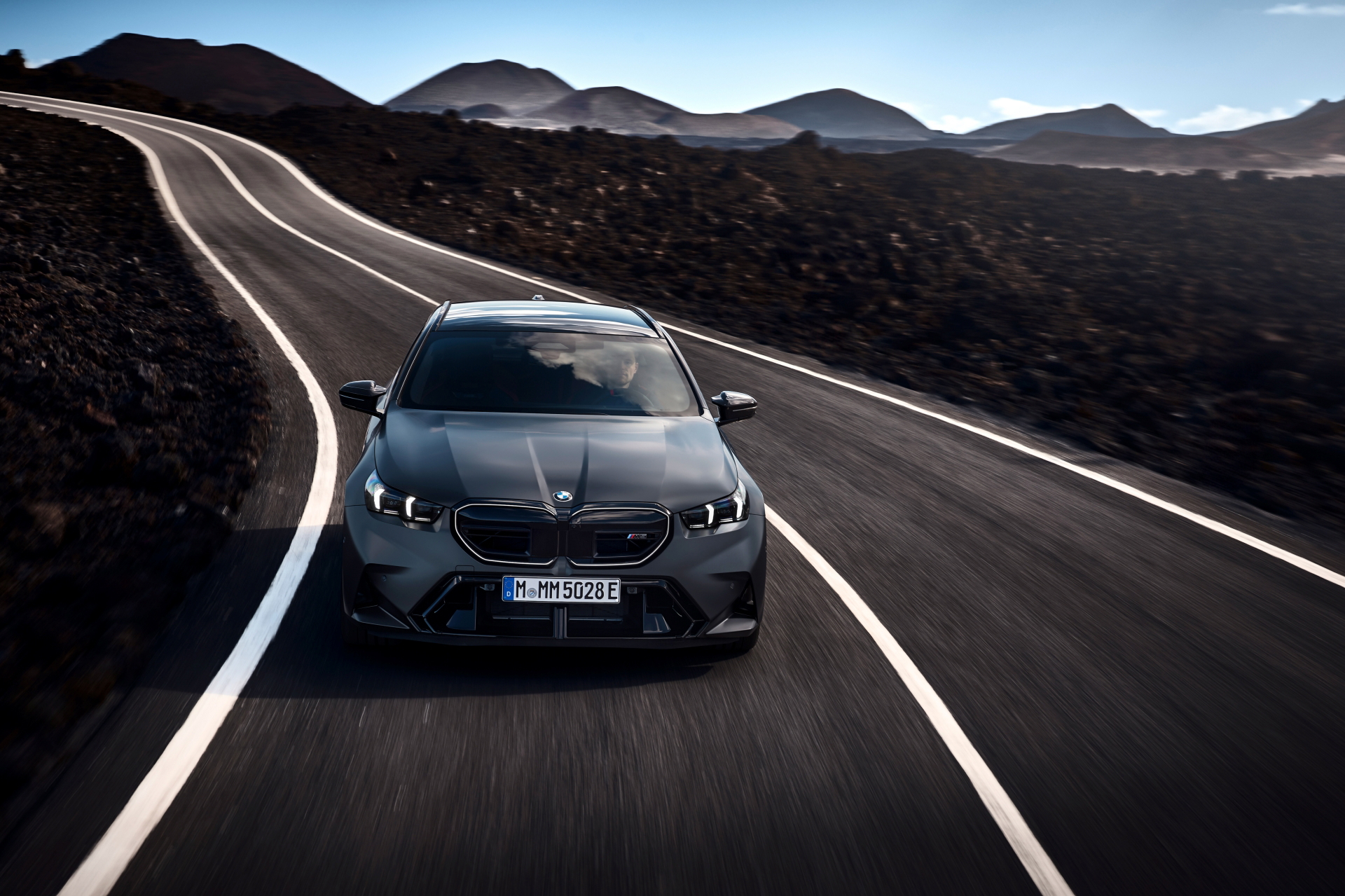 Potente BMW M5 Touring 2025 en carretera serpenteante.