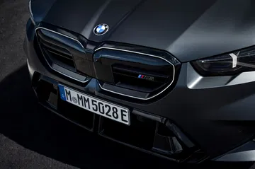 Vista agresiva del frontal del BMW M5 Touring, destacando su parrilla y ópticas.