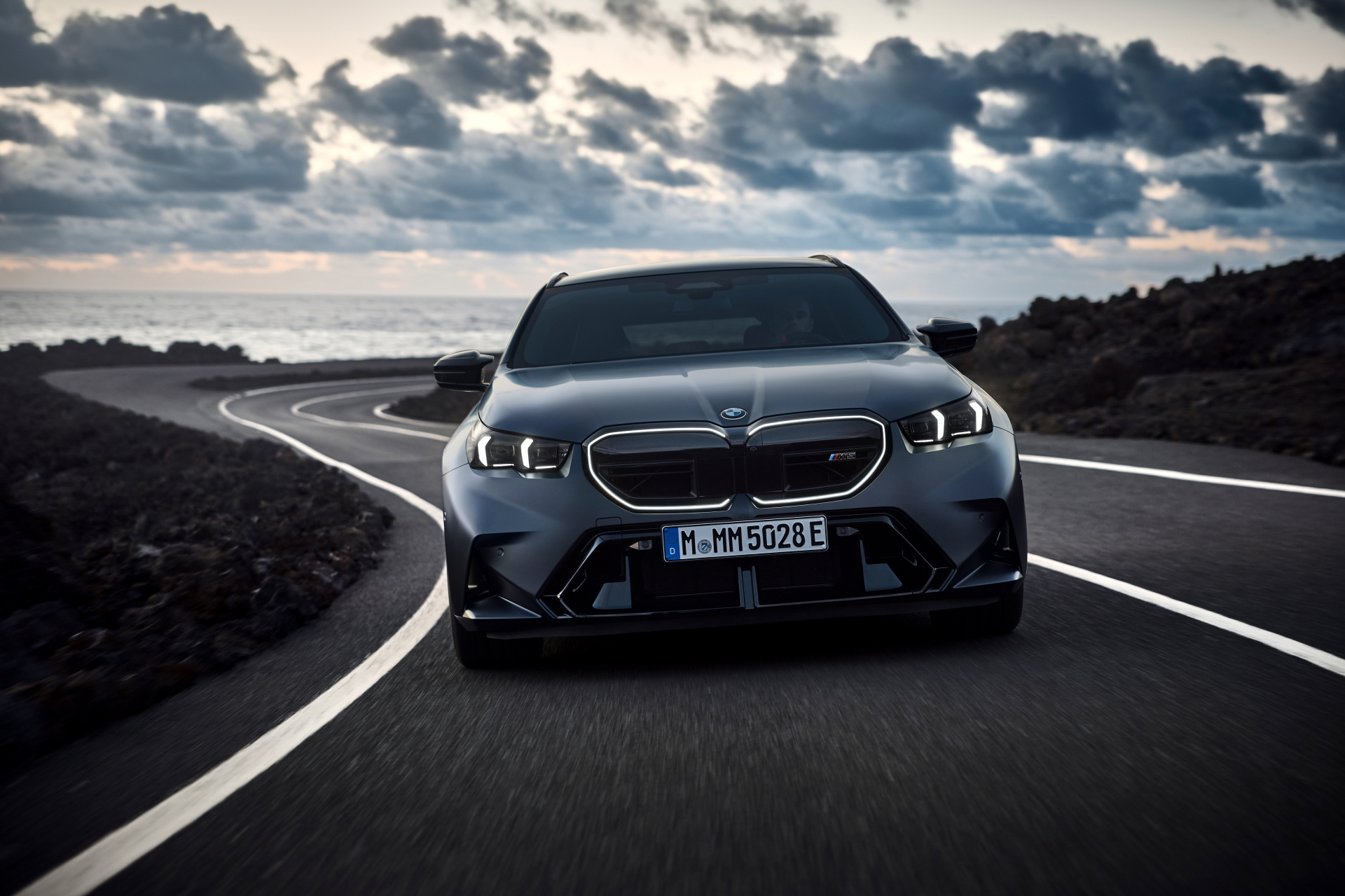 Vista frontal agresiva del BMW M5 Touring 2025 en carretera