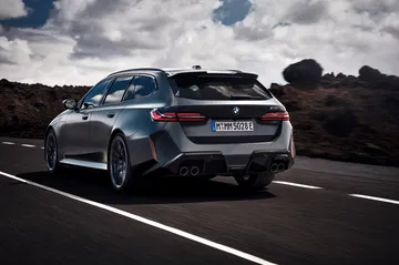 Vista dinámica del BMW M5 Touring mostrando su imponente trasera y perfil lateral.