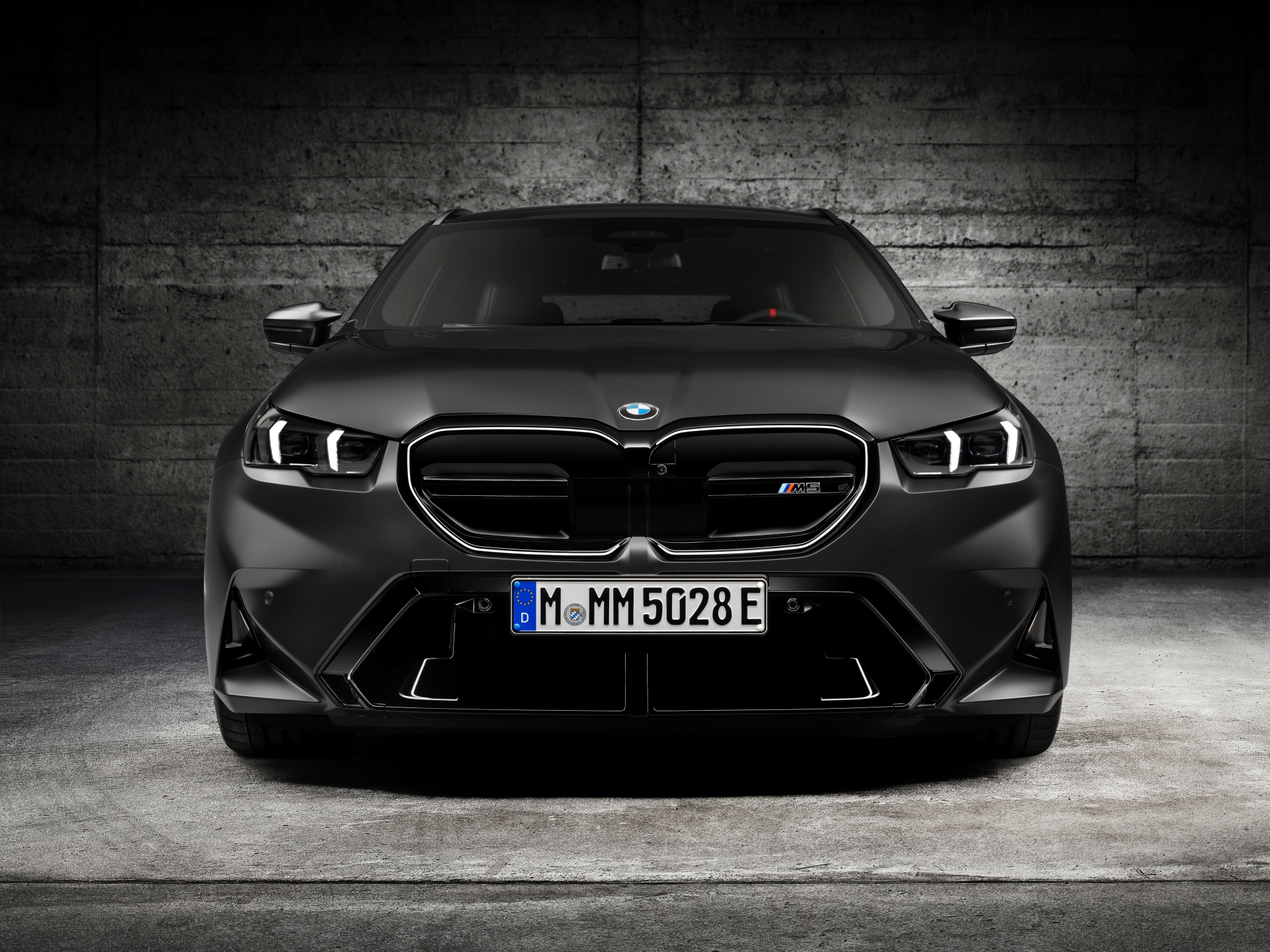 Imagen frontal del BMW M5 Touring ilustrando su robusto diseño y faros agresivos.