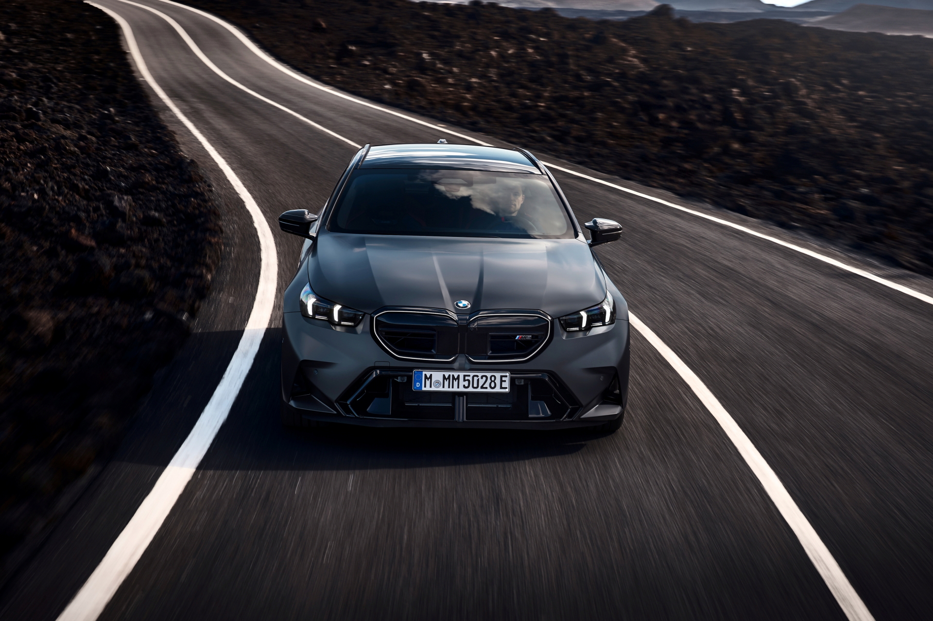 Vista frontal del BMW M5 Touring 2025 en carretera, imponente y elegante.