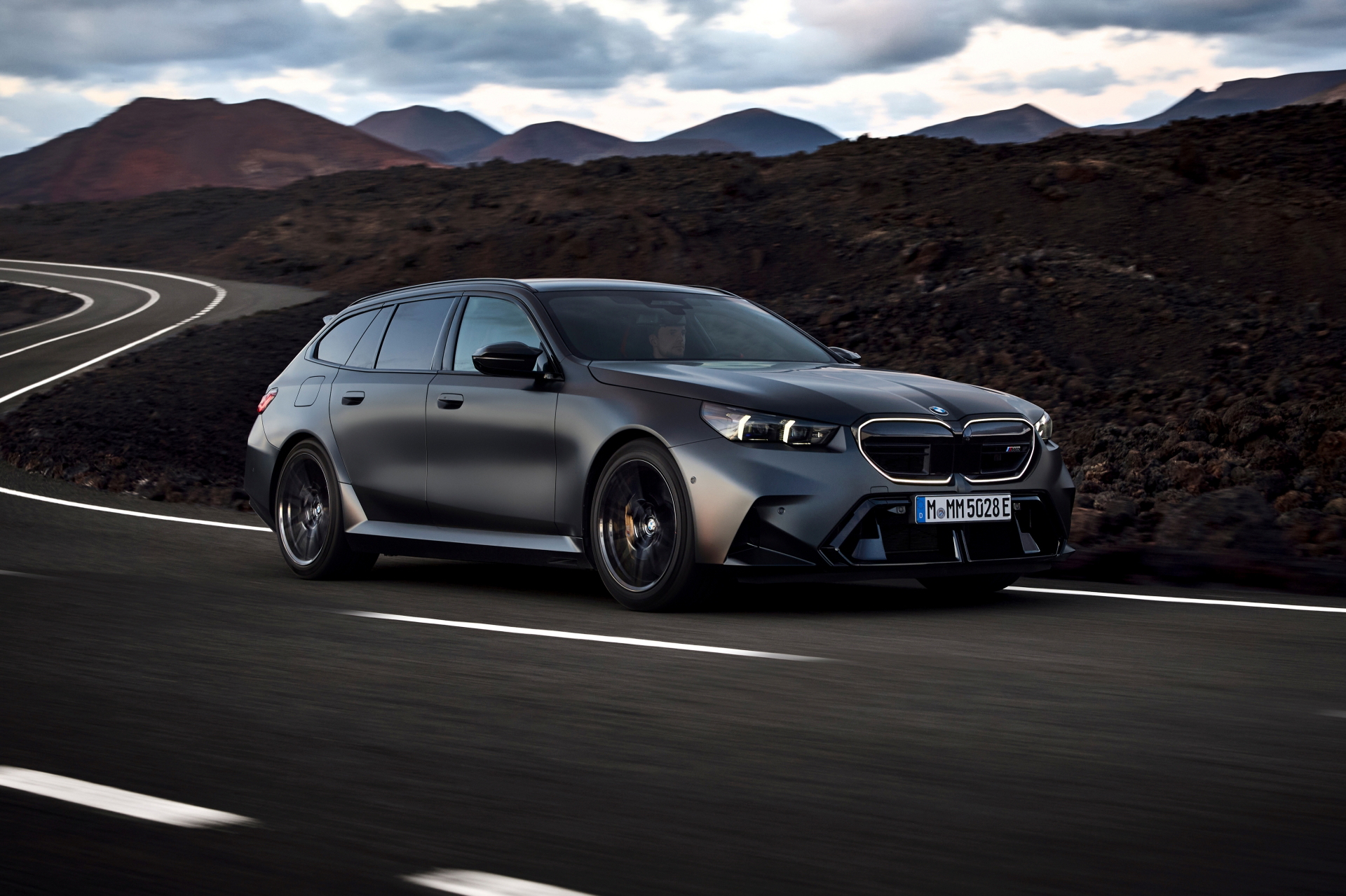 BMW M5 Touring 2025 mostrando su perfil lateral en movimiento.