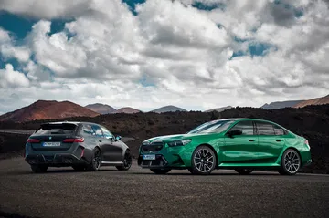 Dos BMW M5 Touring en una imponente vista lateral, exhibiendo líneas y dinamismo.