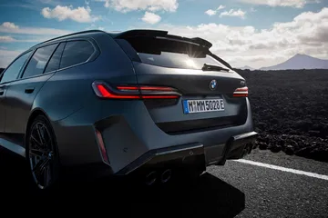 Vista trasera y lateral de un BMW M5 Touring, líneas deportivas y elegancia.