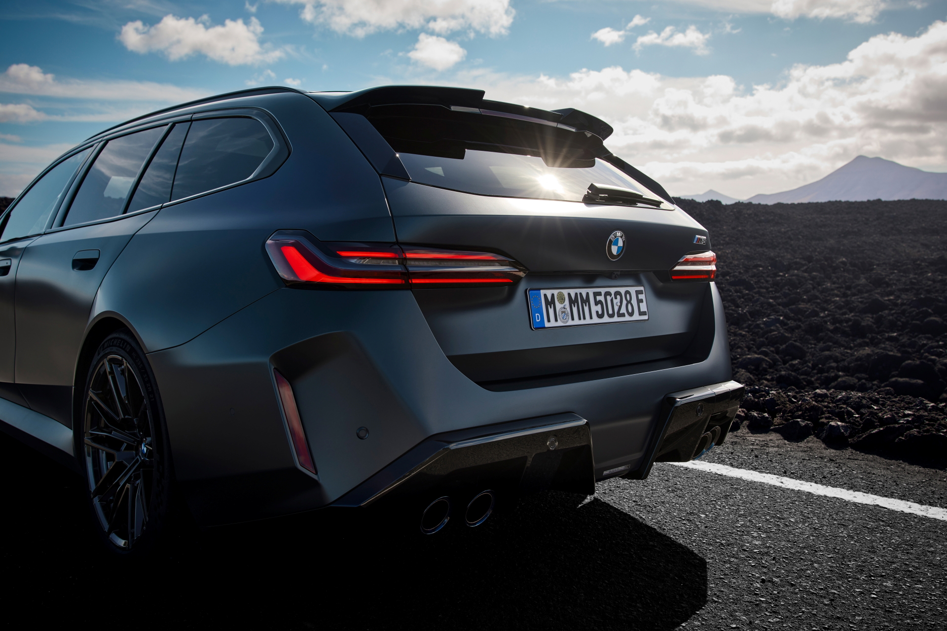 Vista trasera y lateral de un BMW M5 Touring, líneas deportivas y elegancia.