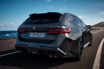 Vista dinámica de la trasera y lateral del BMW M5 Touring 2025, exhibiendo su robustez y diseño elegante