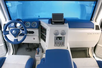 Interior del Oltre Fiat con volante y asientos en tonos azules, panel central con pantallas.